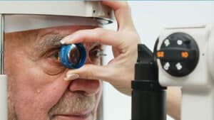 An ophthalmologist uses modern laser equipment to check an elderly person's vision.